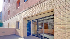 A building with a brick facade, a glass door entrance, and a tiled ground. - Apartment for 3 people, free Wi-Fi in the center of Lloret, 300 meters from the beach, ideal for young people. (Lloret de Mar)