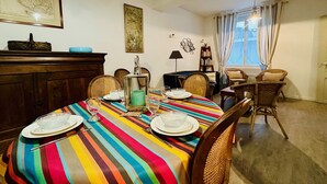 Un comedor con mantel a rayas, sillas de madera y una mesa de buffet.