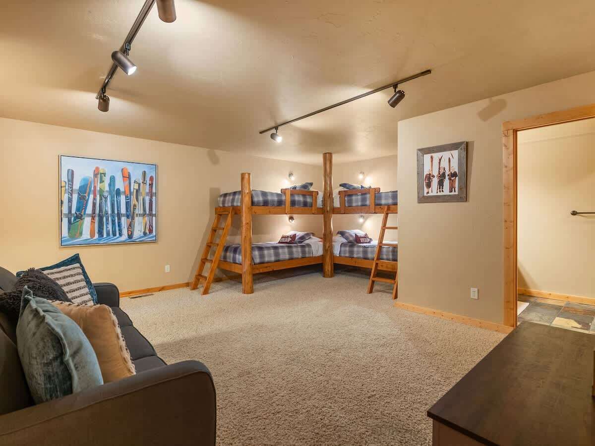Ein Zimmer mit Etagenbetten, einer Schlafcouch und einem Bild an der Wand.
