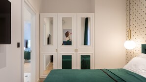 A bedroom with a green bedspread, a wardrobe with mirrors, and a hanging light fixture. - Candy Cavalier Zagreb Center Lux (Zagreb)