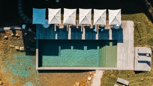 An aerial view of a pool area with multiple umbrellas and lounge chairs. - Hotel Munde (Hofstetten)