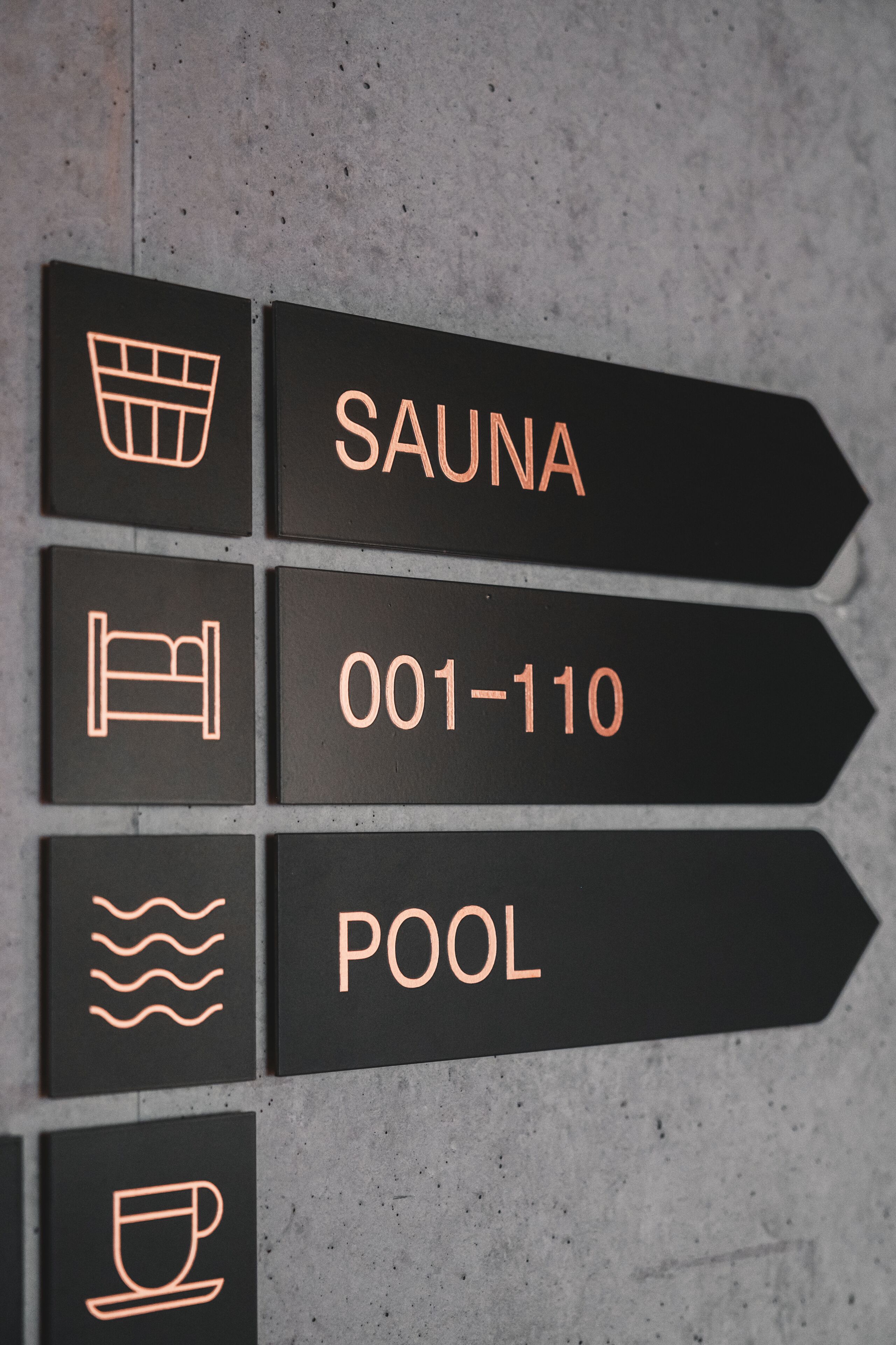 Hinweisschilder für Sauna, Schwimmbad und Zimmernummern 001 bis 110.