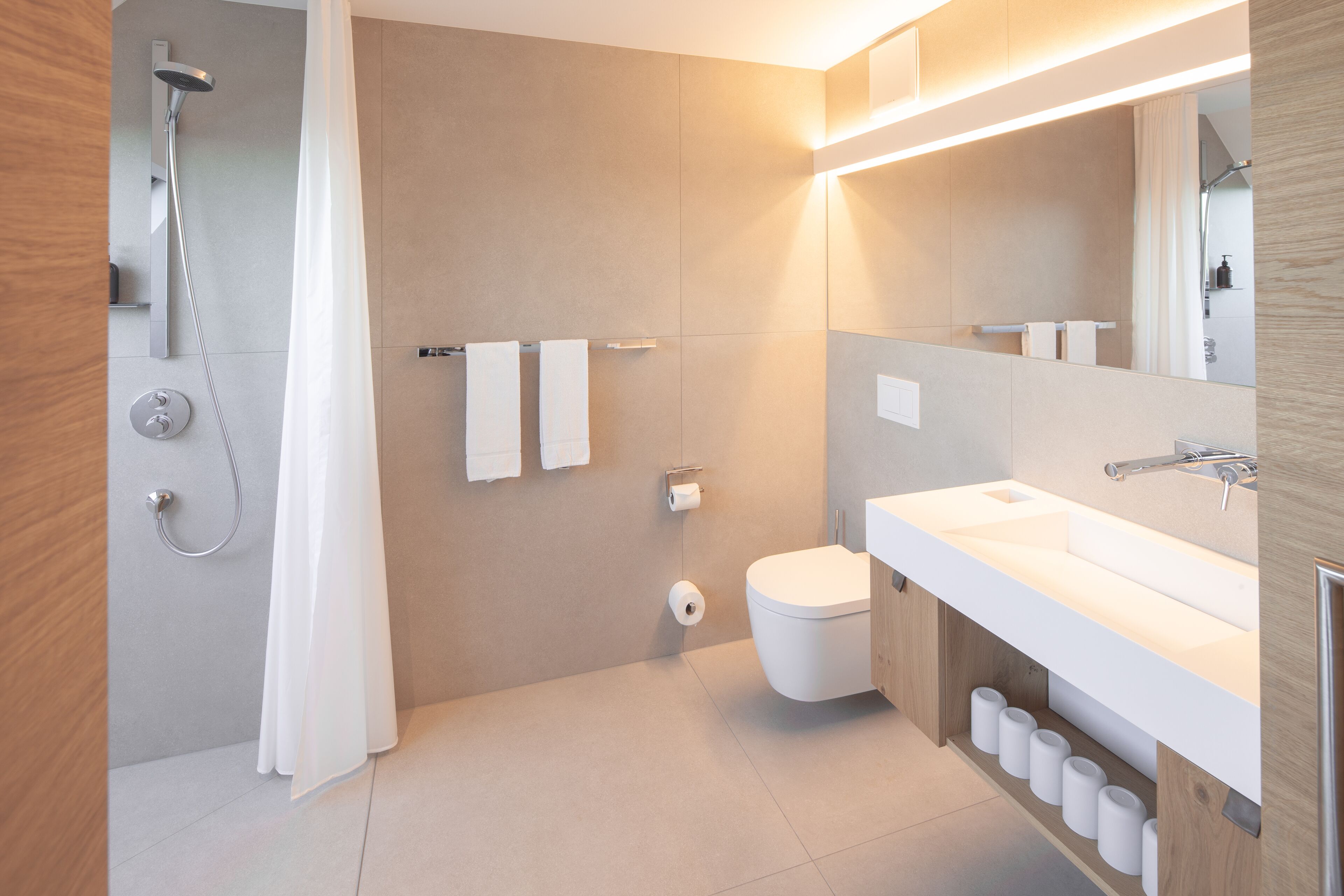 Un baño moderno con ducha, inodoro y lavamanos.