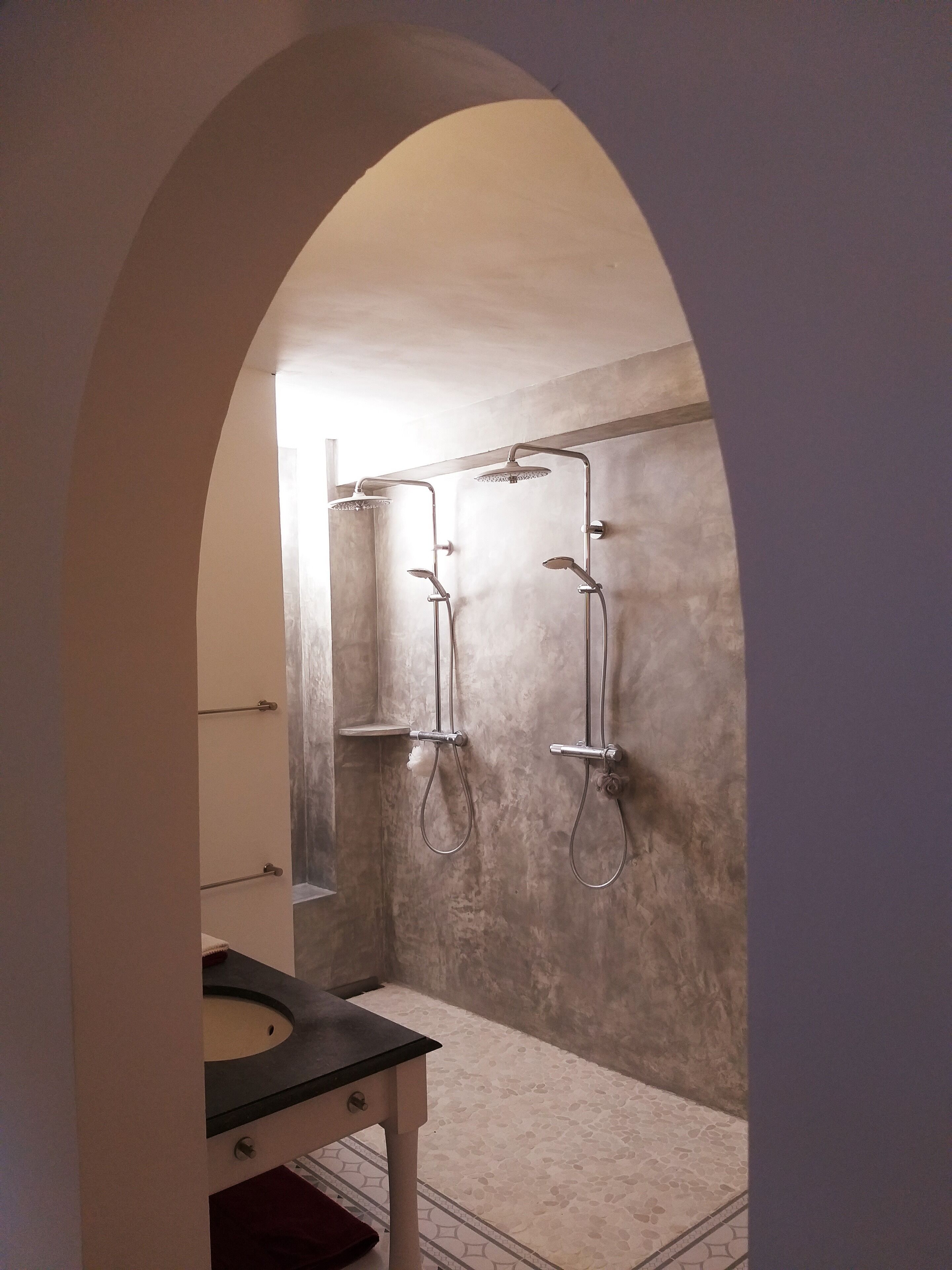 A bathroom with a shower, a sink, and a mirror.