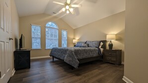 A bedroom with a bed, two windows, a ceiling fan, and a nightstand. - Cedar's Corner in Concord | Spacious & Clean (Concord)