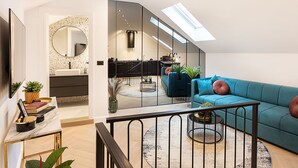 A modern living room with a blue sofa, a coffee table, and a large mirror. - Candy Rose Lux Zagreb Center Apartment (Zagreb)