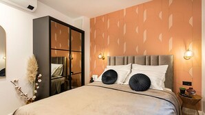 A bedroom with a large bed, a wardrobe, a mirror, and a wall with a geometric pattern. - Candy Rose Lux Zagreb Center Apartment (Zagreb)