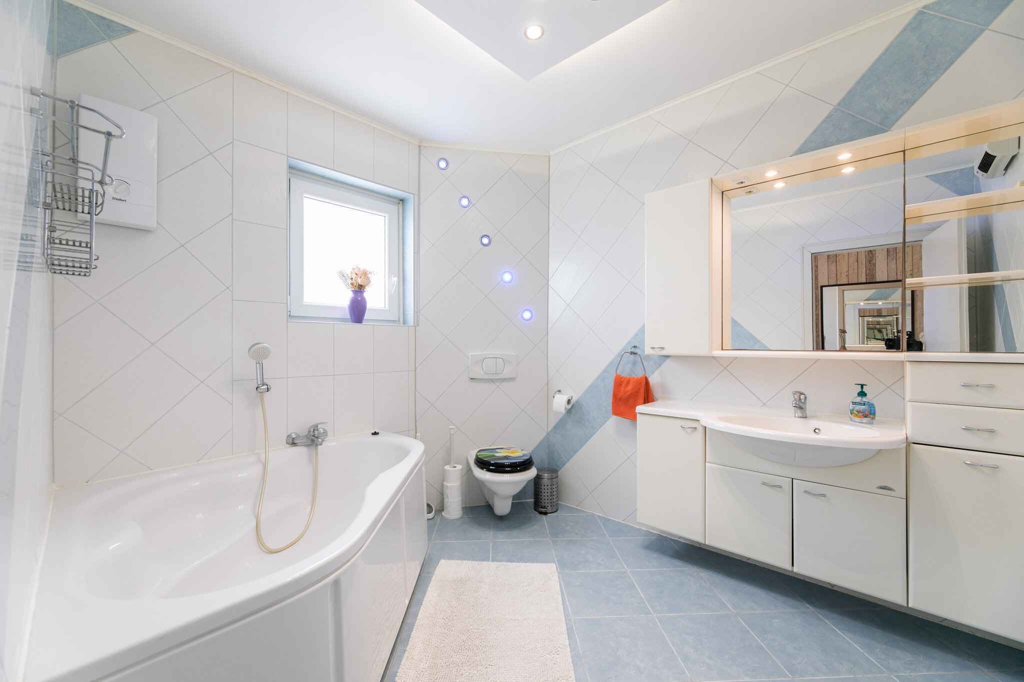 A modern bathroom with a bathtub, toilet, and sink.