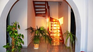 A staircase with a wooden railing, flanked by potted plants, leading to a higher floor. - Villa Fantasia Kefalonia (Kefalonia)