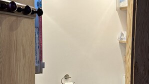 A small, compact bathroom with a toilet, sink, and shower stall.