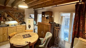A cozy room with a wooden dining table, chairs, a sofa, and a cabinet.