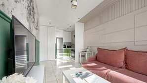 Una sala moderna con un sofá blanco, una mesa de centro y un televisor.