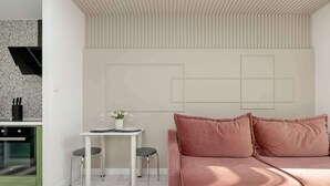 Una sala de estar moderna con un sofá y un comedor con una mesa y sillas.