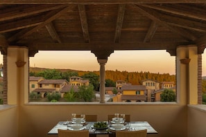 A table set for dining with a view of houses and trees.
