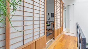 A traditional Japanese room with tatami flooring, a shoji screen door, and a wooden desk with a chair. - Gorgeous home in Paris with WiFi (Paris)
