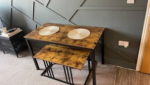 A small wooden table with two woven placemats and a matching bench. - Stylish 1-bed Apartment in Swindon (Swindon)