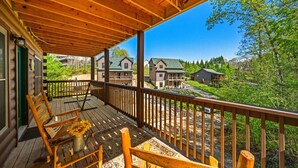 Una terraza de madera con vistas a casas y vegetación.