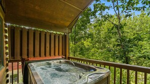 A hot tub on a wooden deck with a view of a forest. - Always Together Forever: Make Memories That Last (Sevierville)