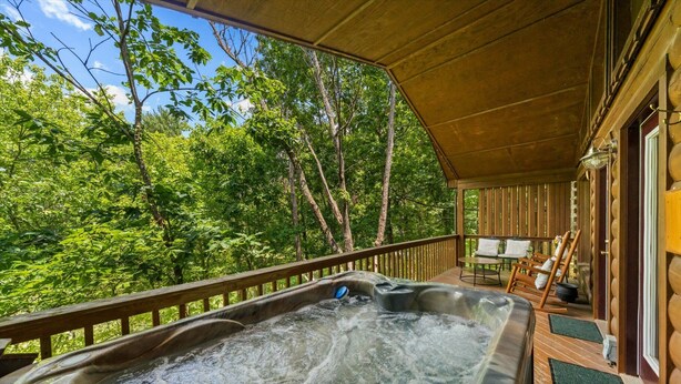 A hot tub on a wooden deck with a view of a forest. - Always Together Forever: Make Memories That Last (Sevierville)