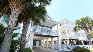 Ein Strandhotel mit zwei Etagen, einer überdachten Außenbereich und einem privaten Steg.
