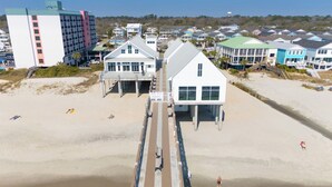 A beachside hotel with a long pier extending into the water, multiple buildings with balconies, and a sandy beach area. - 7 BR 2nd Row Beach House with a Private Pool! Aquadisiac  (Surfside Beach)