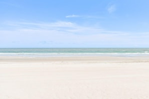 A beach with a clear sky and calm sea.