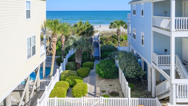 A coastal building with a balcony overlooking the beach, a pathway leading to the beach, and a pool area. - Oceanview 5 BR Beach House with a Private Pool! Blue Lagoon A (Surfside Beach)