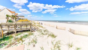 A beach with a wooden boardwalk leading to a building with a red roof. - Oceanview 5 BR Beach House with a Private Pool! Blue Lagoon A (Surfside Beach)