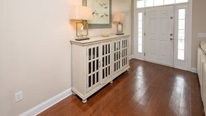 A hallway with a white console table, two lamps, a framed artwork, and a white door. - 4 BR Beach House with a Private Pool! It's A Stone Harbor Thing (Surfside Beach)