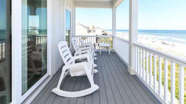 A covered porch with white rocking chairs and a view of the beach. - Oceanfront 8 BR Beach House with a Private Pool! The Emerald (Surfside Beach)