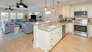A modern kitchen with white cabinetry, granite countertops, and stainless steel appliances. - Just a Walk to the Beach 5 BR Beach House with a Private Pool!  At Ease (Garden City)