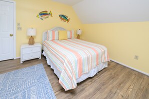 A bedroom with a bed, nightstand, lamp, and a rug. - 3 BR Beach House in Surfside Beach with Shared Pool!  Sea Bridge 1015 (Surfside Beach)