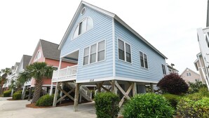 A blue house with a balcony, a number 1018, and a small garden with various plants. - 2nd Row, 3 BR Beach House with Shared Pool in Surfside Beach! Sea Bridge 1018 (Surfside Beach)