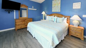A bedroom with a bed, dresser, nightstands, and a TV. - Pet Friendly 6 BR Beach House with a Private Pool in Surfside Beach! Sea La Vie  (Surfside Beach)