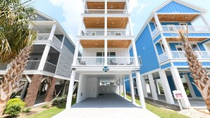 Un edificio de varios pisos con balcones, una entrada cubierta y un cartel que indica que es un resort.