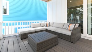 Un área de estar al aire libre con techo, un sofá modular y una mesita de centro.