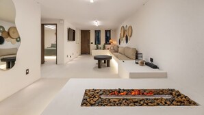 Un salon moderne avec une cheminée en pierre, un canapé et une table basse.