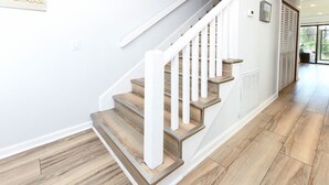 A staircase with wooden steps and white railings in a modern interior. - 2 Bedrooms Townhouse in Surfside Beach! Dottie's Place (Surfside Beach)