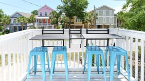 A deck with a table and four blue bar stools. - Walk to the Beach 3 BR Beach Condo in Surfside Beach! Family Tides (Surfside Beach)