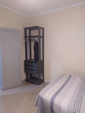 A bedroom with a bed, a wardrobe, and a door. - Vila Tupy, a 100 m da Praia (Vila Assuncao Praia Grande)