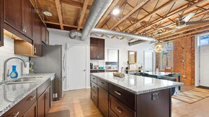 Una cucina moderna con pensili in legno scuro, un piano di lavoro in granito e un'isola centrale.