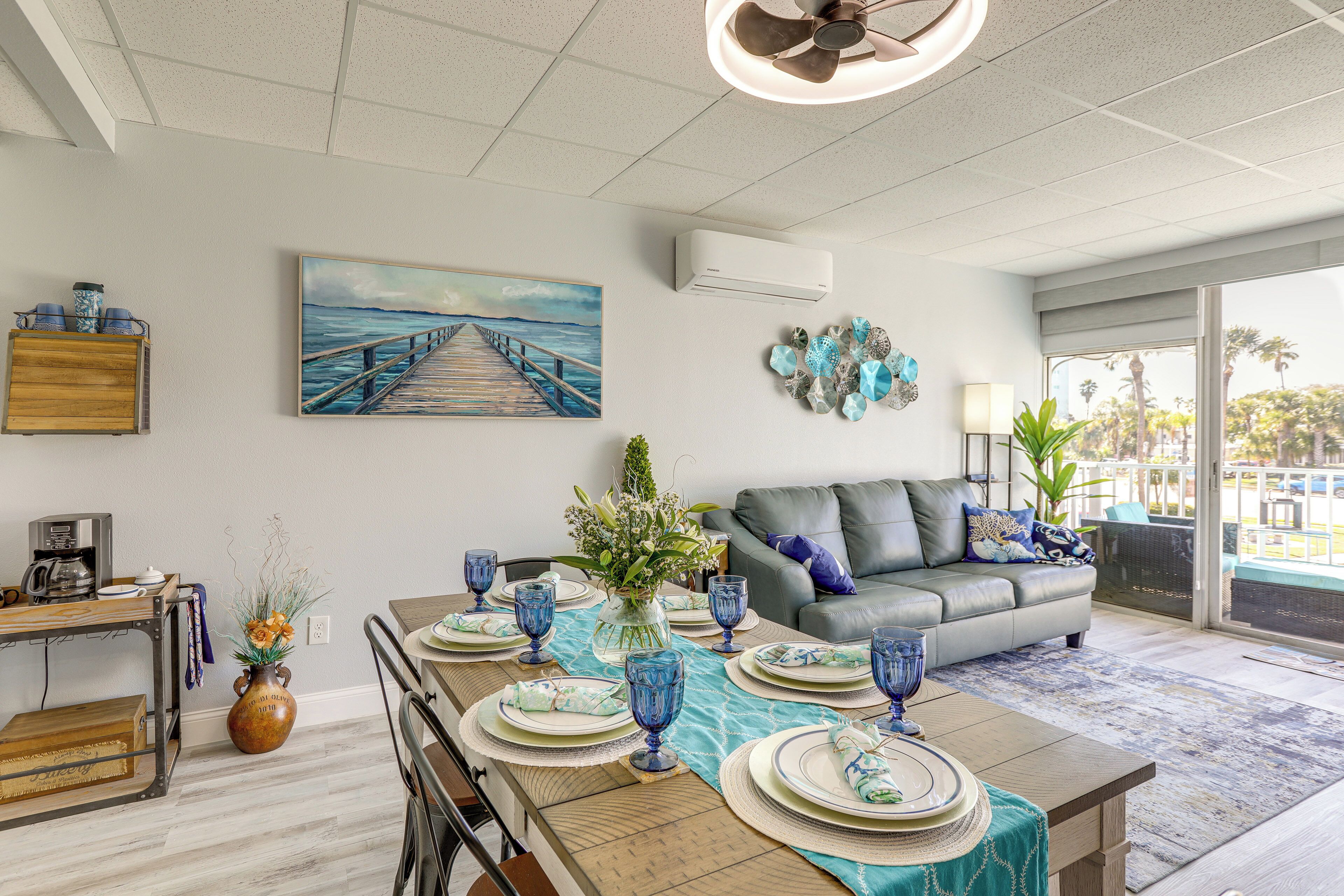 A dining area with a table set for four, a sofa, and a view of the outdoors.