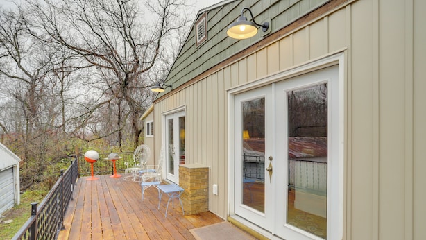 A wooden deck with outdoor furniture, a brick planter, and a sliding glass door leading to a covered area. - Vintage Coloma Home w/ Deck: Shop, Swim & Dine! (Coloma)