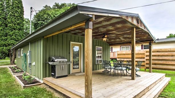 A wooden deck with a covered patio, a grill, and outdoor furniture. - Lake Pepin Cottage w/ Patio - Walk to the Marina! (Pepin)