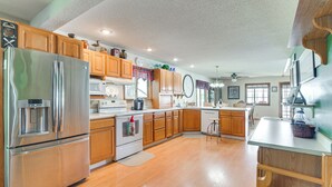 Una cocina moderna con gabinetes de madera, electrodomésticos de acero inoxidable y una isla grande.