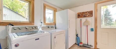 A compact kitchen with a washer and dryer, a stove, and a refrigerator.