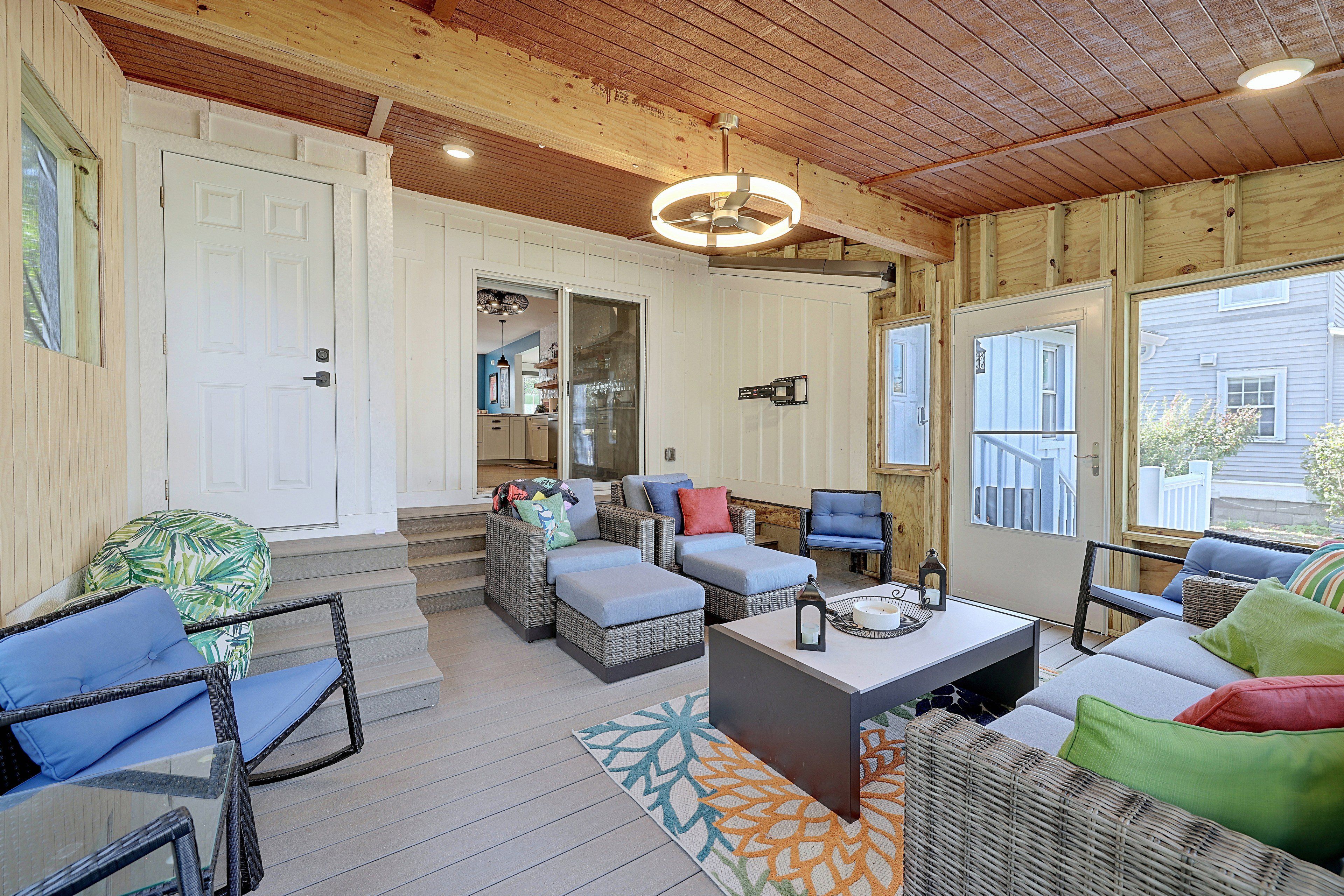 A cozy living room with wicker furniture, a ceiling fan, and a view of the outside.