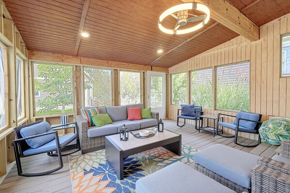 A sunlit room with a wooden ceiling, large windows, a sofa, chairs, and a coffee table. - 17 Mi to Ski Slopes! Retreat Near Lake Michigan (Frankfort)