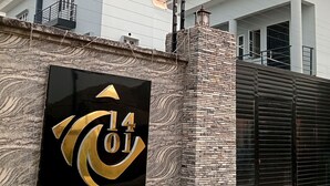Een bord met 'Luxury Apartments', met een modern gebouw op de achtergrond.