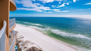 Ein Hotel direkt am Strand mit einem geschwungenen Balkon mit Blick auf den Ozean.